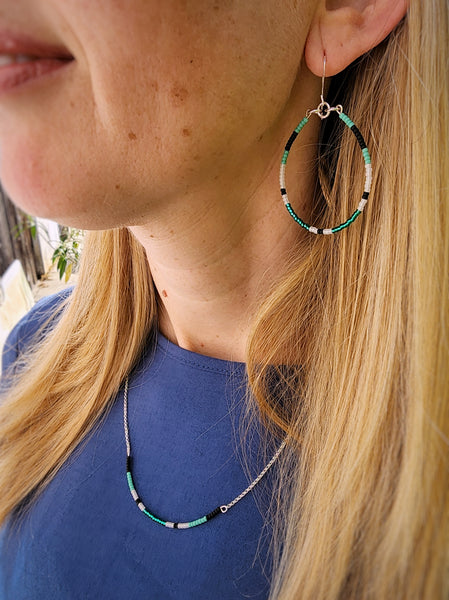 Model wearing sunrise collection hoops and necklace