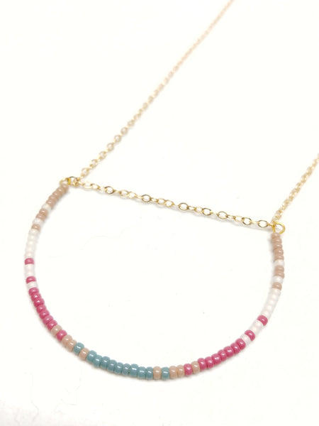 Gratitude Necklace: Gold plated delicate chain, U-shaped focal piece featuring seed beads in beige, white, mulberry and cyan.