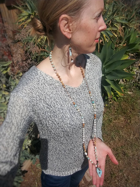 Model wearing Larimar Mala Necklace at full length, paired with Calming Waters Earrings.
