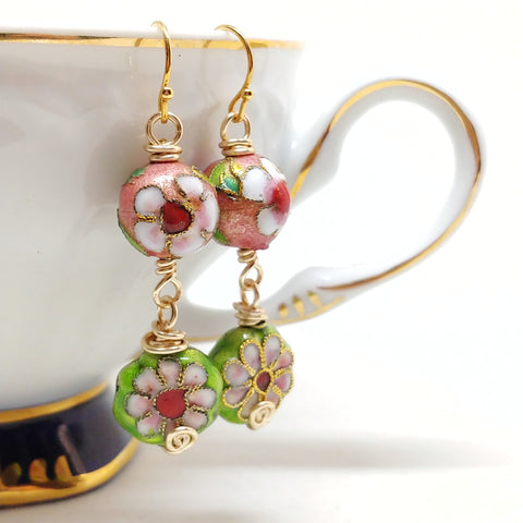 Dangly cloisonné bauble earrings featuring vibrant pinks and greens with daisy motifs.