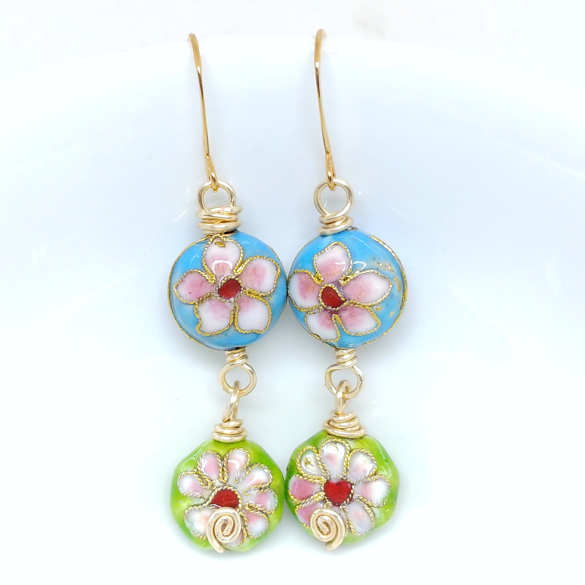 Gold cloisonné bauble earrings featuring vibrant blues and greens with daisy motifs.