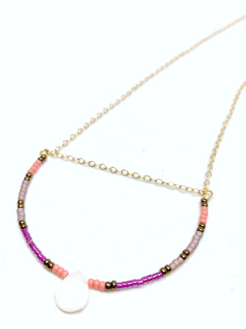 Joyful Necklace: Delicate gold chain with U-shaped focal piece featuring seed beads in bronze, salmon, amethyst and plum, and a mother of pearl teardrop.
