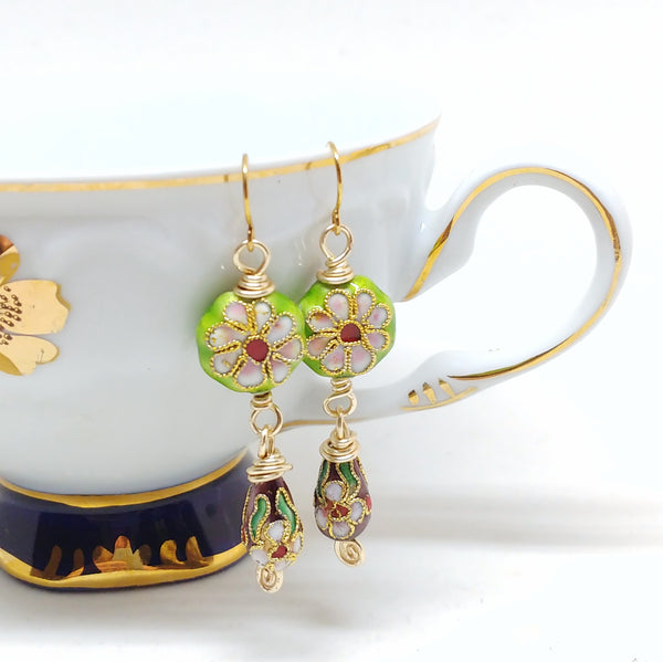 Gold dangly cloisonné bauble earrings featuring vibrant green and burgundy with daisy motifs.