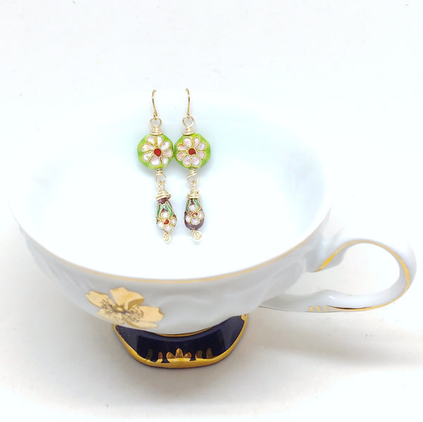 Gold dangly cloisonné bauble earrings featuring vibrant green and burgundy with daisy motifs.