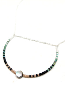 Peaceful Necklace: Sterling silver featuring a U-shaped focal piece with Abalone and seed beads in white, turquoise, black and beige.