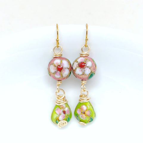 Gold dangly cloisonné bauble earrings featuring vibrant pinks and greens with daisy motifs.