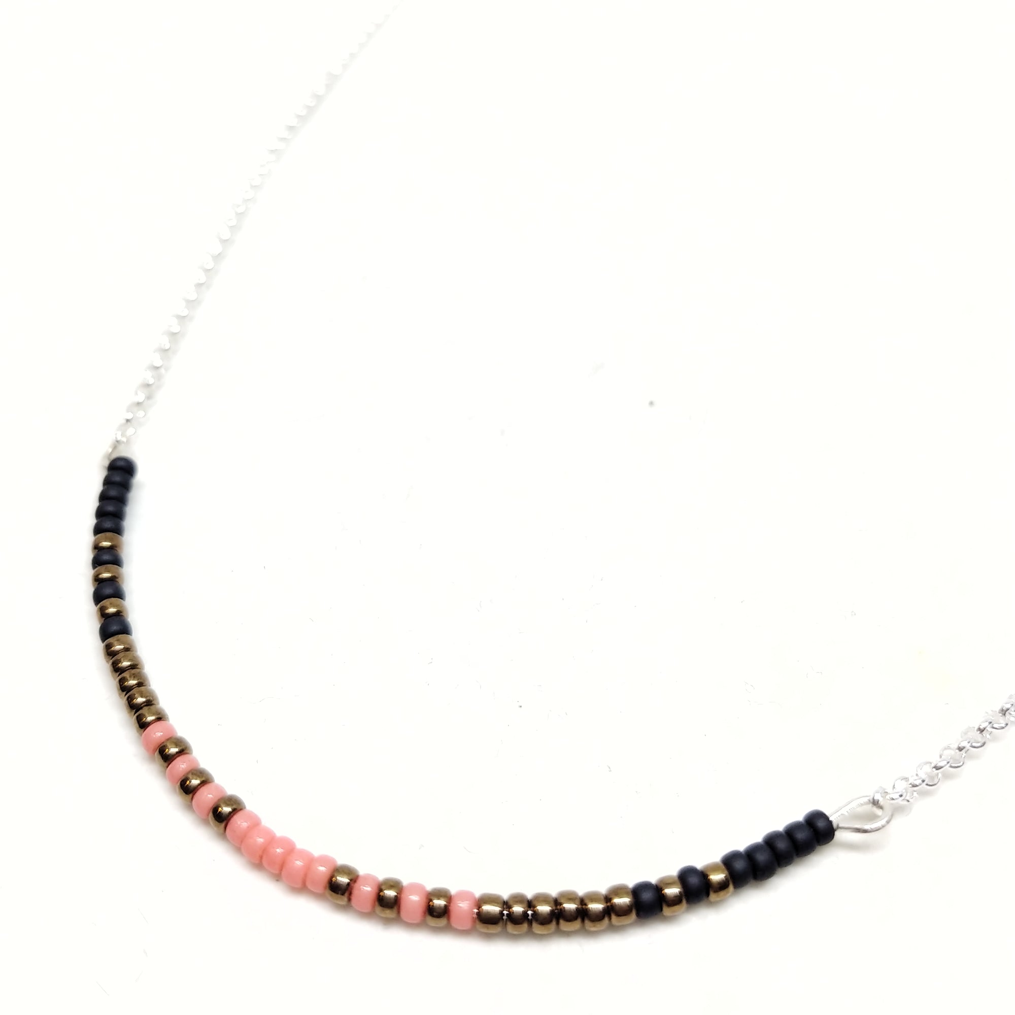 Ready To Rise Necklace: Sterling Silver chain featuring focal piece with seed beads in salmon, black and bronze.
