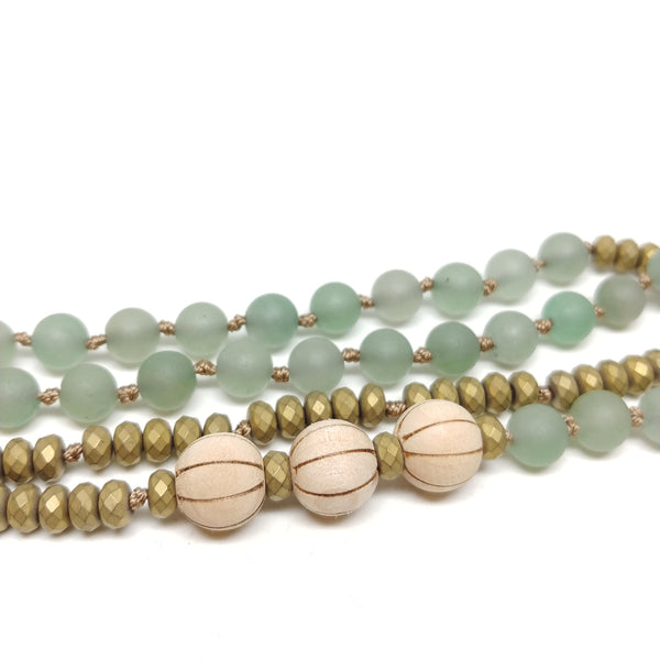 Detail of Culp Valley Necklace, long 108 bead knotted mala necklace, grass jasper, aventurine, bodhi seeds, brass sunburst pendant
