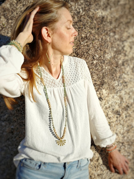 Model wearing Culp Valley Necklace, long 108 bead knotted mala necklace, grass jasper, aventurine, bodhi seeds, brass sunburst pendant