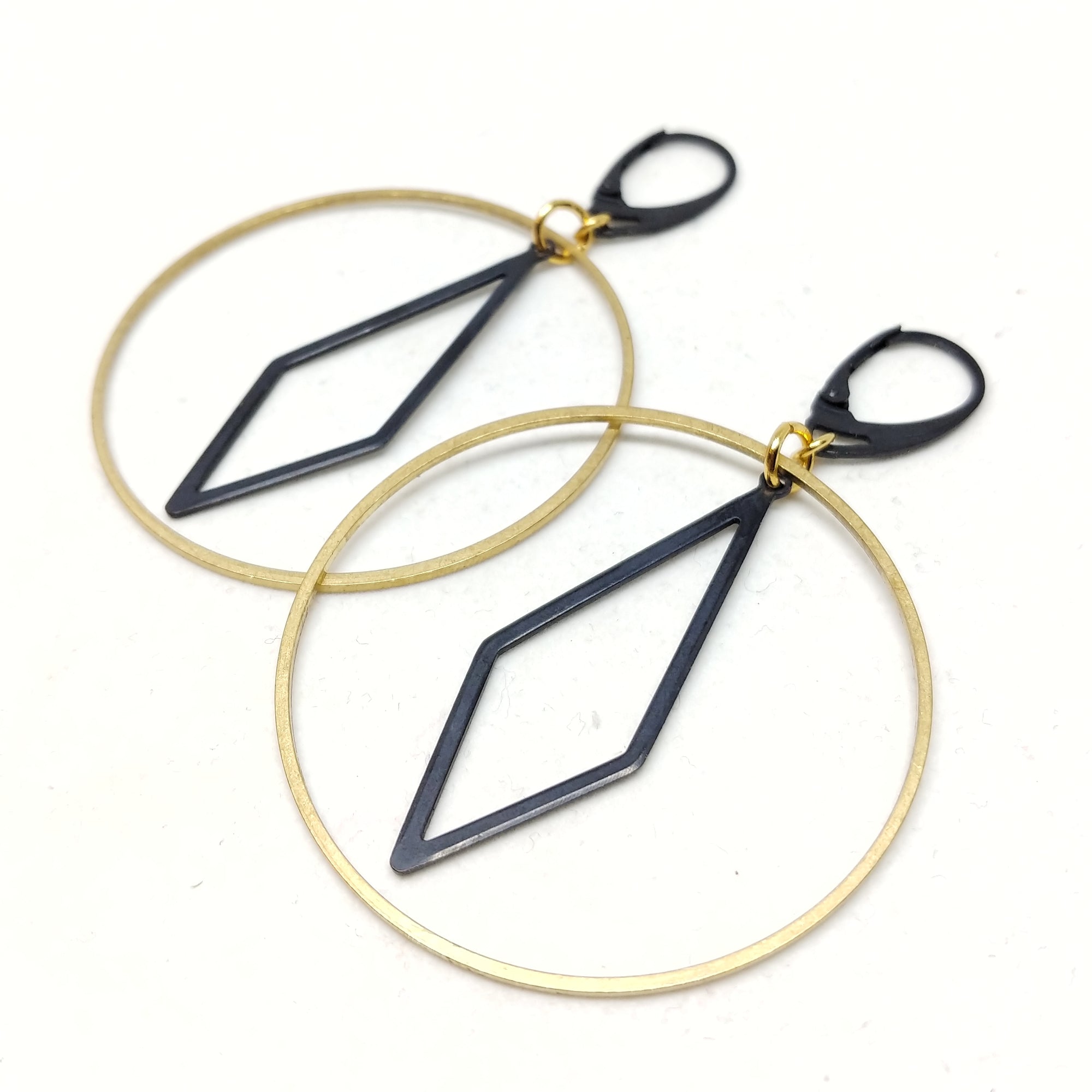 Diamond Hoops featuring black oxidized brass lever-back ear wires and oblong diamond inside of a raw brass hoop, 65mm top to bottom