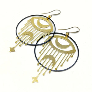 All brass statement hoops with crescent moon eyes and falling stars.