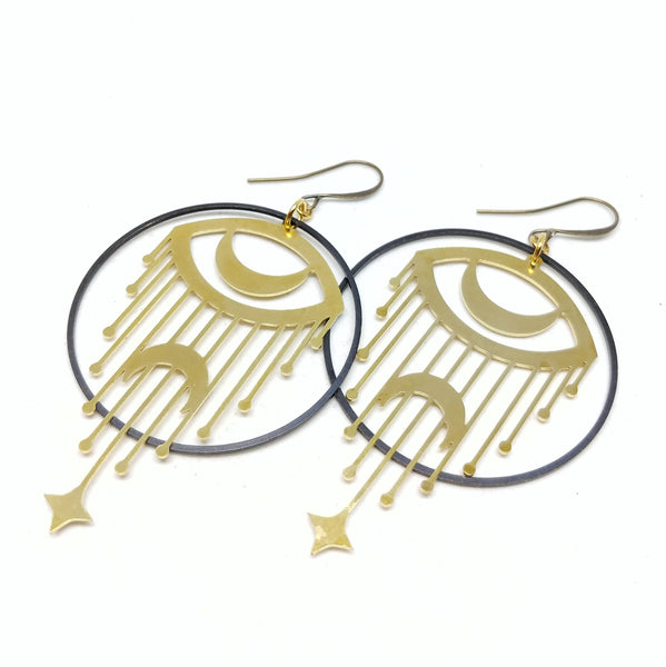 All brass statement hoops with crescent moon eyes and falling stars.