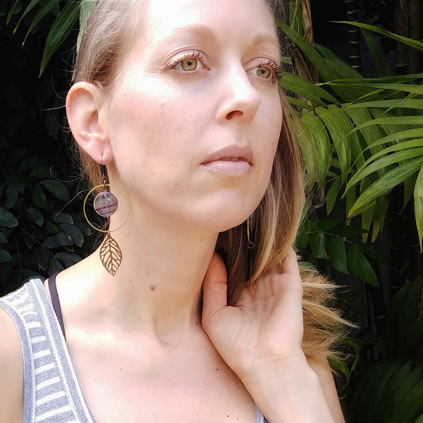Model wearing Flourite hoops, antique and raw brass, leaf embellishment, flourite beads, fringe benefits collection