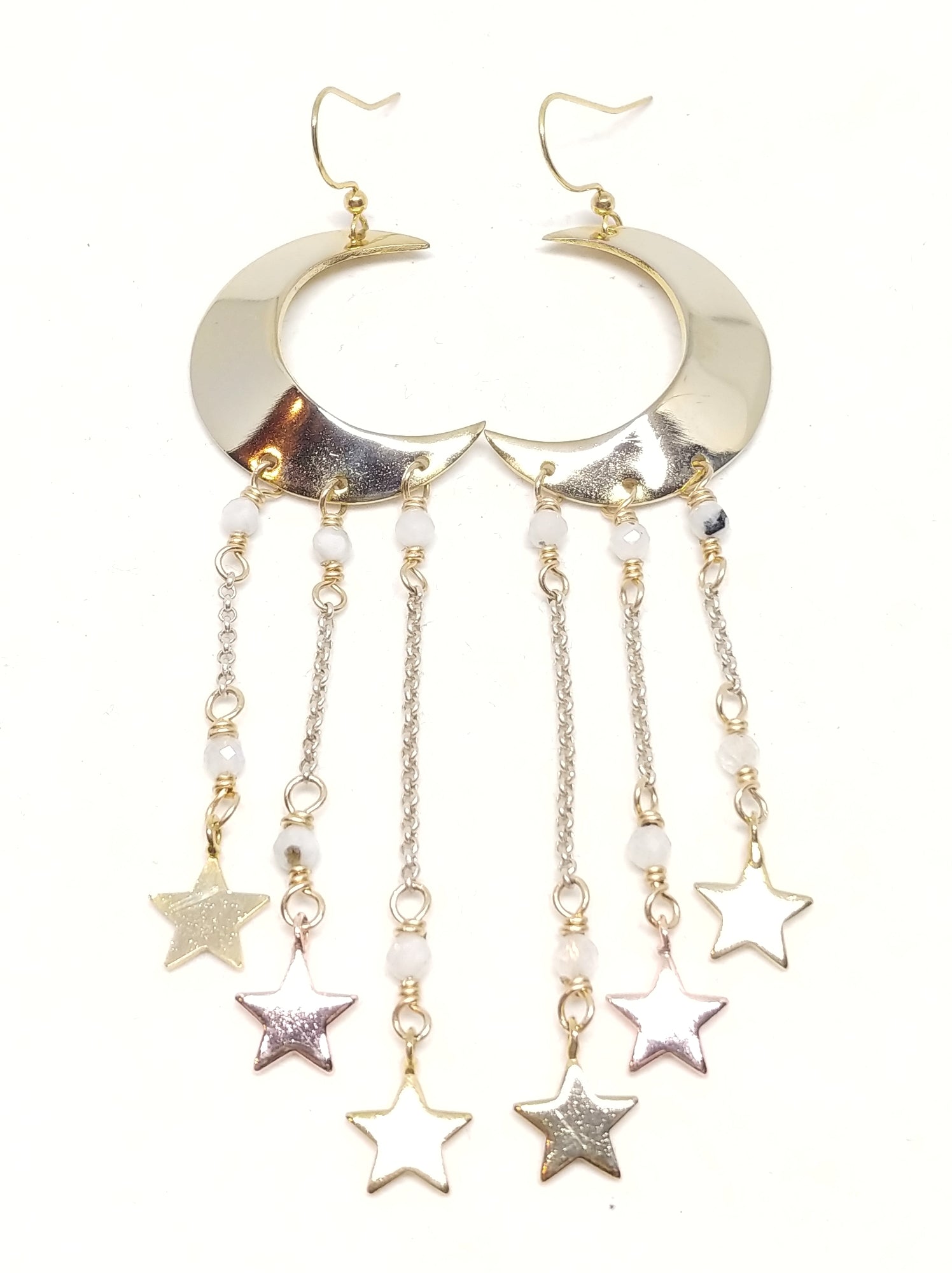 Large gold crescent moon earrings with shiny stars dangling from underneath by silver chain and moonstone accents.