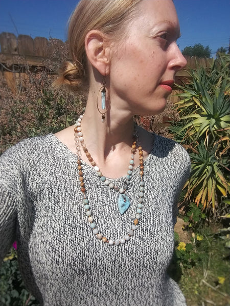 Model wearing Larimar Mala Necklace doubled up with pendant at collar bone length, paired with Calming Waters Earrings.