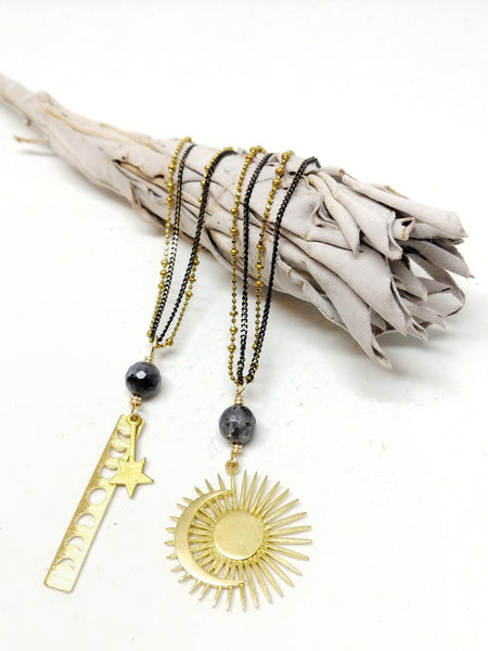 Close up of Moon Phase Necklace next to Harmony in Opposing Forces Necklace.