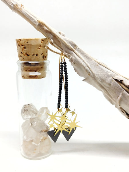 70mm gold plated kidney wire earring in my signature style with black crystals, brass starburst charm and black triangle charm, shown hanging.