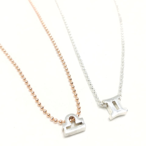 Zodiac choker in rose gold-plated ball chain and sterling silver rolo chain, each featuring one tiny silver-plated zodiac charm.